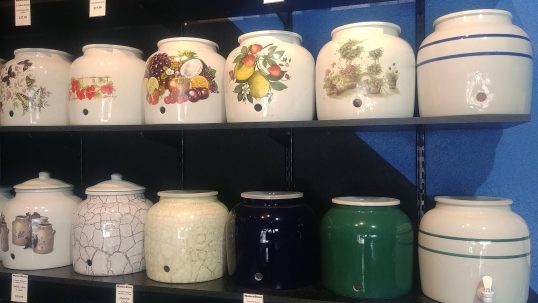 An assortments of decorative ceramic crocks for up to 5 gallon bottles